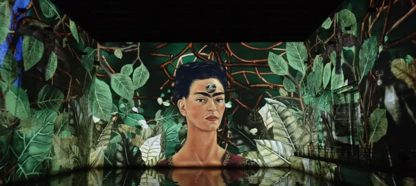 Exhibition of Frida Kahlo's paintings, reflecting in the water, at the immersive digital art center