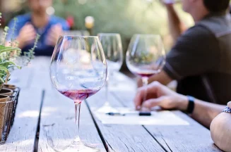 Outdoor wine tasting in Saint-Emilion, with people sittting around a wooden table
