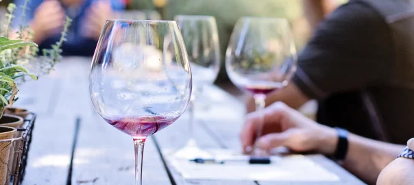 Outdoor wine tasting in Saint-Emilion, with people sittting around a wooden table
