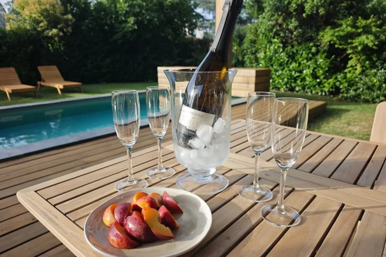 Chilled bottle of Crémant at Numa House, served by the pool in its ice bucket with fresh peaches
