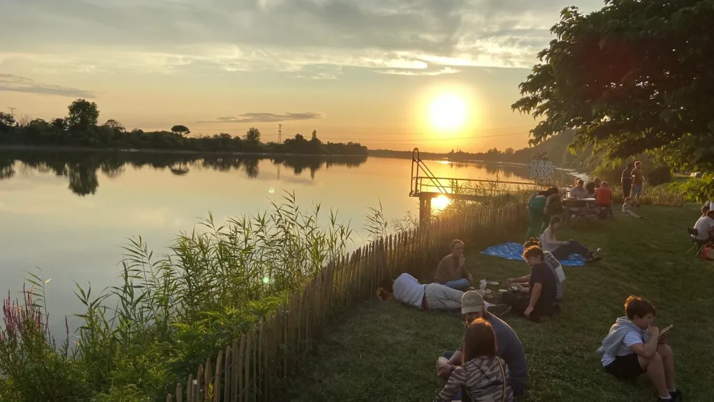 Sunset reflecting on the Garonne River, view from the bank in Cambes, during a local summer party